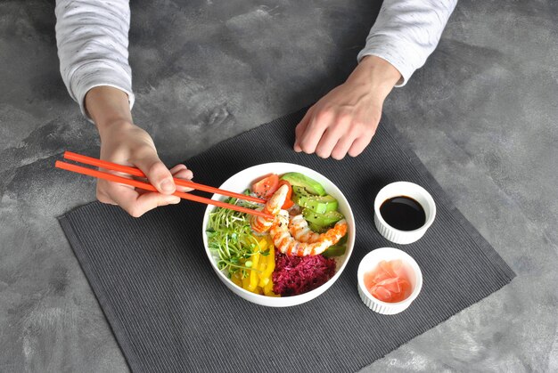 Recette de fruits de mer frais. Poke bowl de crevettes avec riz, chou rouge, avocat, poivron jaune