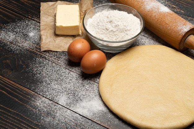 Recette de pâte feuilletée roulée et non cuite sur fond de bois