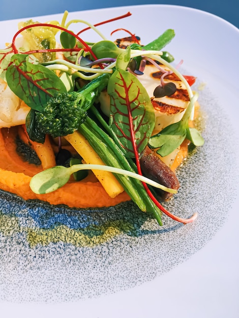 Recette saine d'aliments biologiques et de salades végétariennes dans un restaurant de luxe, légumes chauds avec fromage vert et herbes servis sur assiette