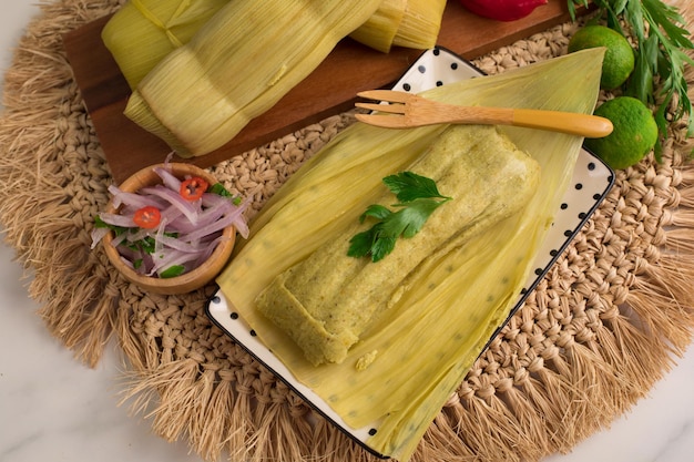 Une recette de tamales est préparée avec des ingrédients frais comme la coriandre, l'oignon rouge et la coriandre.