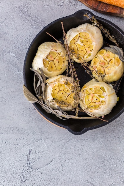 Recette de tartinade à l'ail rôti faite avec des épices dans une poêle en fonte.