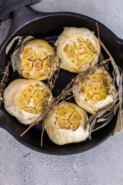 Recette de tartinade à l'ail rôti faite avec des épices dans une poêle en fonte.