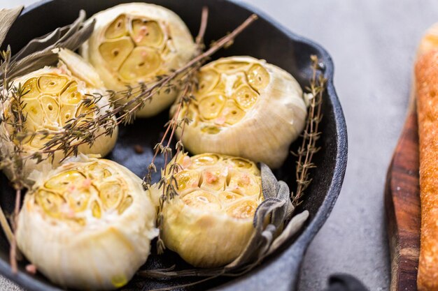 Recette de tartinade à l'ail rôti faite avec des épices dans une poêle en fonte.