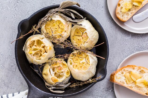 Recette de tartinade à l'ail rôti faite avec des épices dans une poêle en fonte.