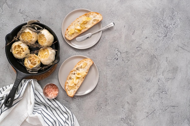 Recette de tartinade à l'ail rôti faite avec des épices dans une poêle en fonte.