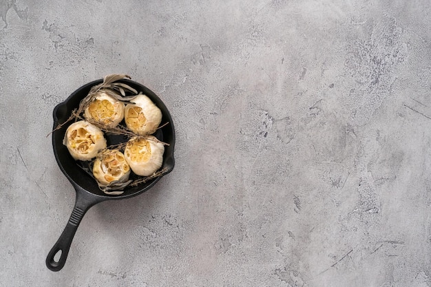 Recette de tartinade à l'ail rôti faite avec des épices dans une poêle en fonte.