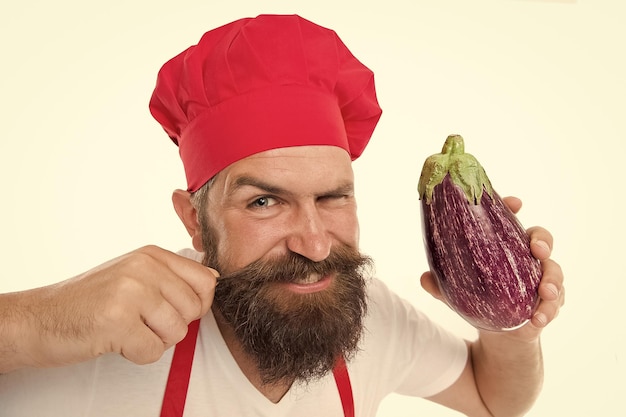 Recette végétarienne Manger des aliments frais Chef végétarien cuisiner des aliments Restaurant végétarien Concept de cuisine saine Homme avec barbe fond blanc Le chef tient l'aubergine Le cuisinier en uniforme tient les légumes