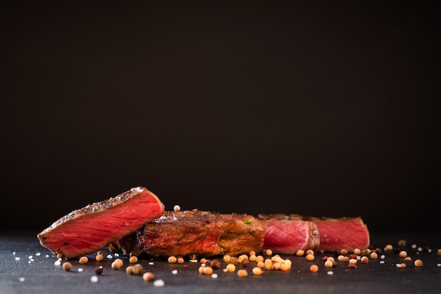 Recette de viande rôtie Bifteck rare aux épices Copiez l'espace sur fond noir