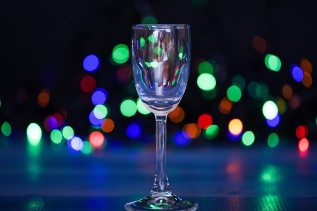 Recettes faciles pour les cocktails alcoolisés d'hiver. Verre à cocktail sur guirlande de lumières colorées défocalisées. Que boire à la fête de Noël. Cocktail d'alcool pour la fête d'hiver. Concept d'idées de cocktails.