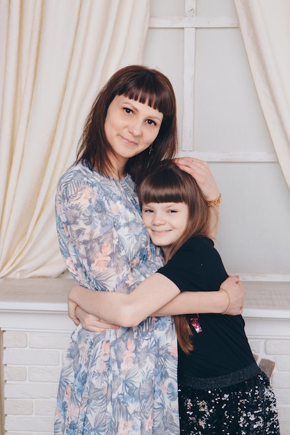 Réchauffant et relaxant près de la cheminée. Mère et fille étreignant. Concept de famille, maternité, intérieur, maison, enfance, fête des mères, journée des enfants