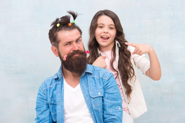 À la recherche d'un bon coiffeur et salon de coiffure bonne fête de la famille petite fille jouer avec papa homme barbu père s'amusant avec enfant journée des enfants amour et confiance fille et père avec une coiffure drôle