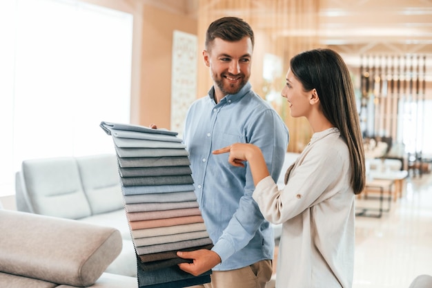 À la recherche de la bonne couleur Couple choisissant le canapé et le lit dans le magasin