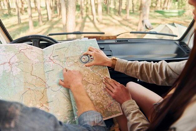 À la recherche d'un emplacement à l'aide d'une carte Un groupe de jeunes voyage ensemble dans la forêt pendant la journée