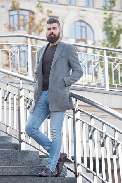 À La Recherche D'un Hipster Mature Brutal à La Mode En Veste D'automne Mâle Avec Un Mec Aux Cheveux Faciaux Soignés Avec Une Coiffure élégante Soins Des Cheveux Et De La Barbe Homme D'affaires Charismatique Avec Barbe à Pied Homme Barbu En Plein Air