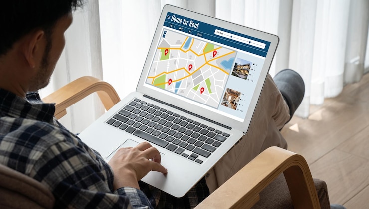 Photo recherche en ligne de locations immobilières confortablement sur l'ordinateur