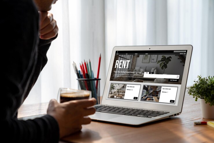 Photo recherche en ligne de locations immobilières confortablement sur l'ordinateur