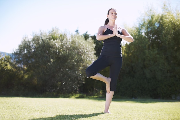 À la recherche de la paix dans le jardin Plan complet d'une jolie femme pratiquant le yoga