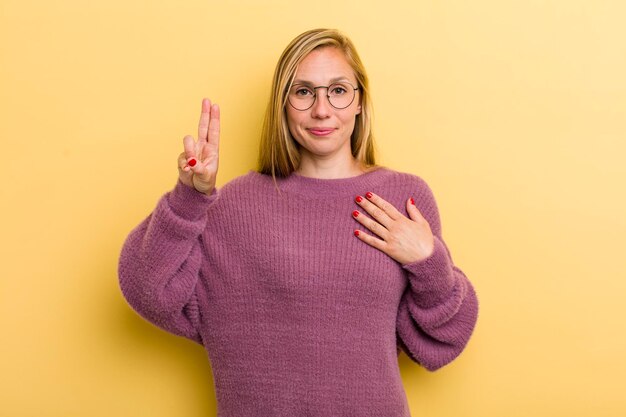 à la recherche de sourire heureux confiant et digne de confiance et montrant un signe de victoire avec une attitude positive