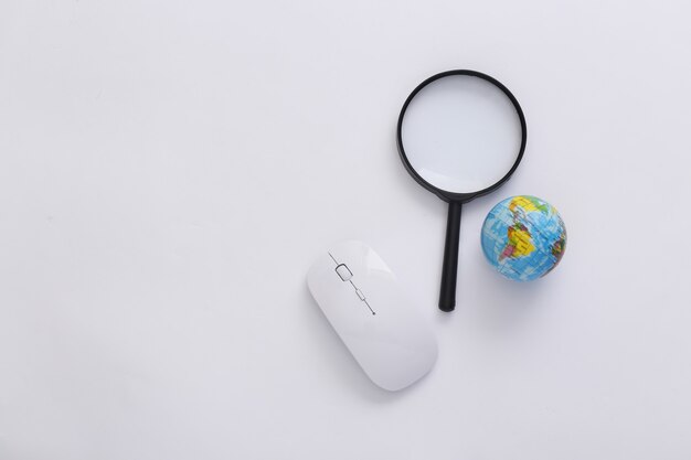 Rechercher des informations. Souris PC, loupe, globe sur fond blanc. Vue de dessus