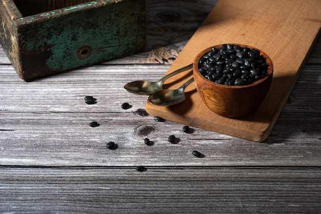 Récipient en bois avec des haricots noirs