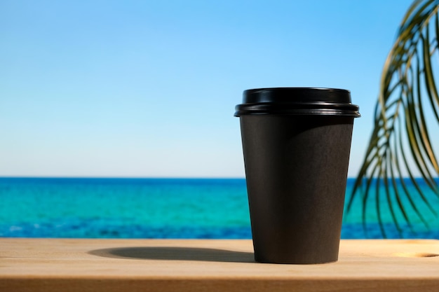 Récipient jetable pour boissons chaudes sur la plage tropicale