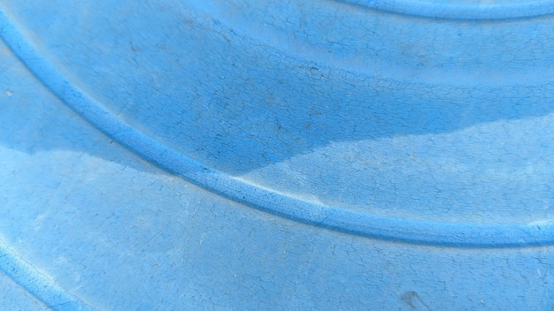 Un récipient en plastique bleu avec une ligne courbe au fond.