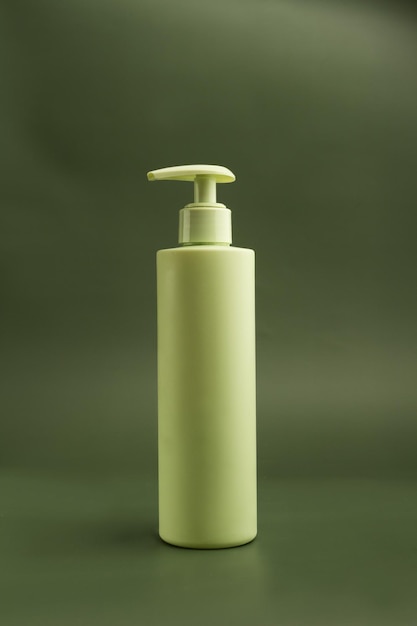 Récipient en plastique pour gel pour le visage ou distributeur de savon de couleur vert clair sur fond vert foncé