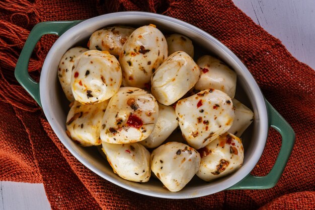 Récipient en porcelaine avec boules de mozzarella de bufflonne assaisonnée