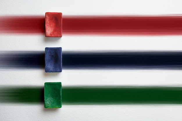 Récipient rouge, bleu et vert de peinture aquarelle sur fond de rayures multicolores