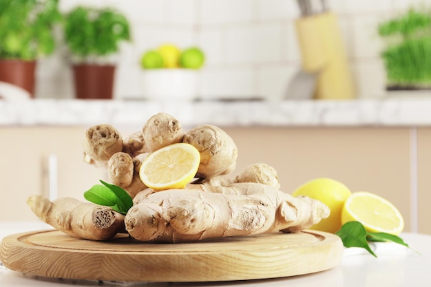 Récolte d'automne, racine de gingembre frais et citron sur le fond de la cuisine à la maison. Gingembre frais sur la table de la cuisine. Médecine naturelle. Immunité et santé.