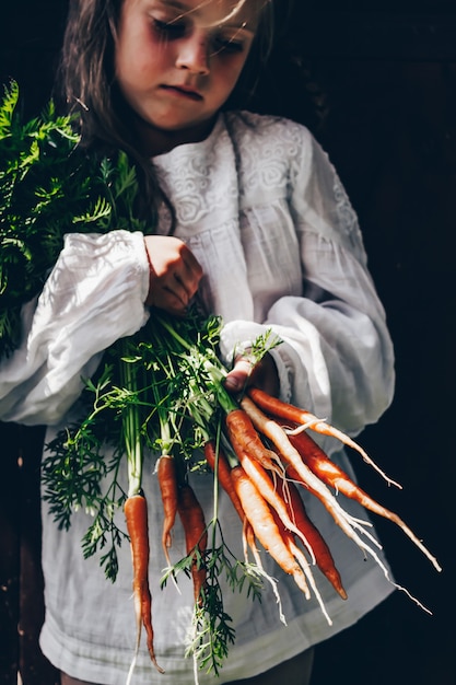 récolte de légumes dans les mains d'une petite fille