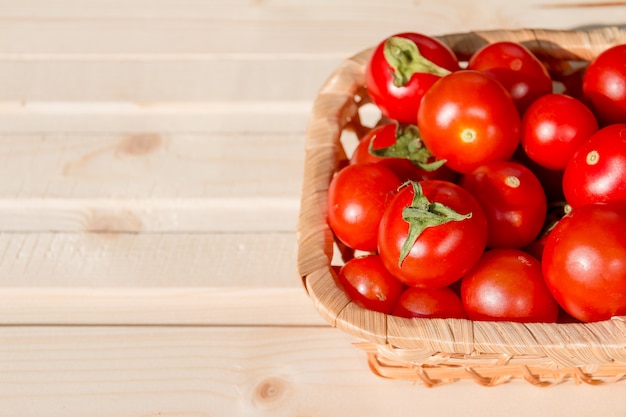 récolter les tomates dans le panier en osier sur table en bois