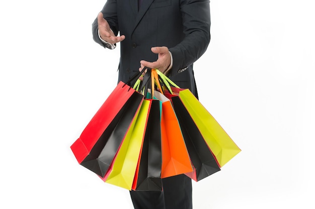 Recommander d'acheter. Les mains du client portent des sacs à provisions sur fond blanc. Un homme d'affaires prospère ne choisit que des marques luxueuses et fait du shopping dans des boutiques à la mode. Vente au rabais d'entreprise.