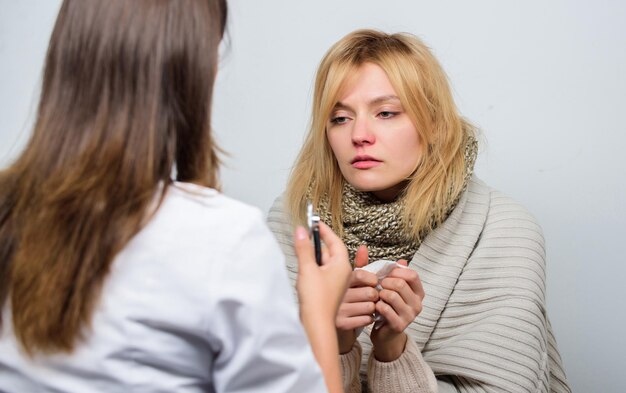 Reconnaître les symptômes du rhume. Examen médical. Concept de médecin et de patient. Symptômes de fièvre chez l'adulte. Traitement et quand appeler un médecin. Une femme médecin examine une personne malade. Service de médecin visite à domicile.