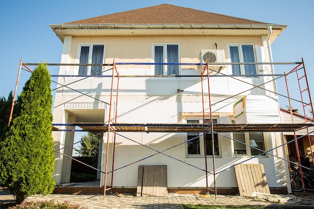 Photo reconstruction de la maison isolation de la maison avec enduit de mousse de polystyrène application de plâtre