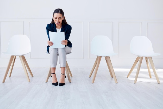 Recrutement papier et embauche d'une femme d'affaires dans une salle d'attente pour un entretien d'embauche dans une entreprise Sourire enthousiaste et contrat pour la promotion de la réussite professionnelle ou une nouvelle carrière tout en lisant un document