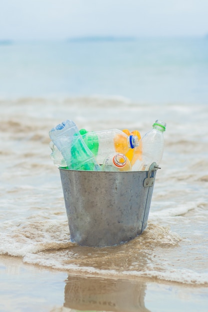 Recycler, panier avec bouteille en plastique à la plage