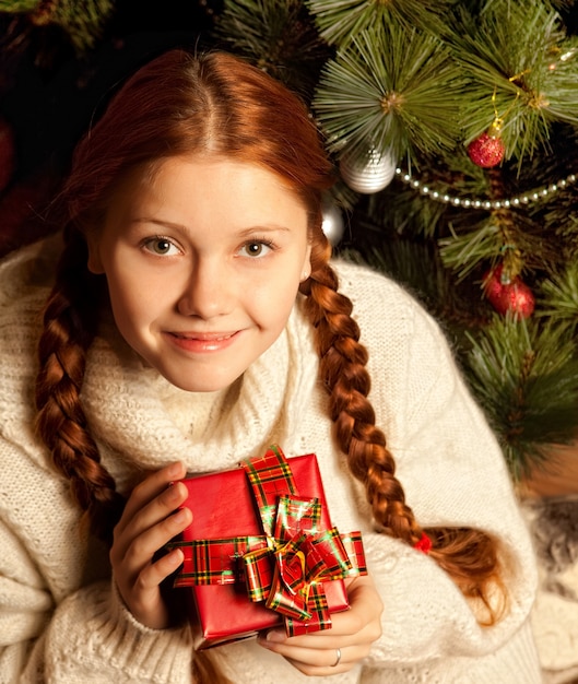 Redhair femme avec cadeau de Noël dans un intérieur de maison