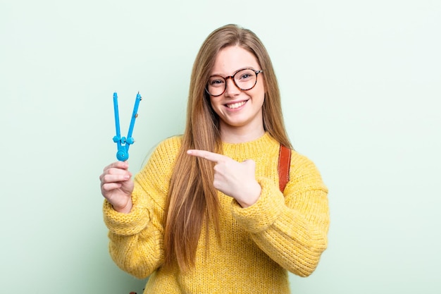 Redhair souriant joyeusement se sentant heureux et pointant vers le concept de dessin de la boussole latérale