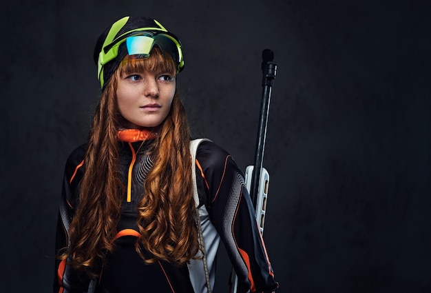 Redhead Biatlon femmes sportives à lunettes détient une arme de compétition.