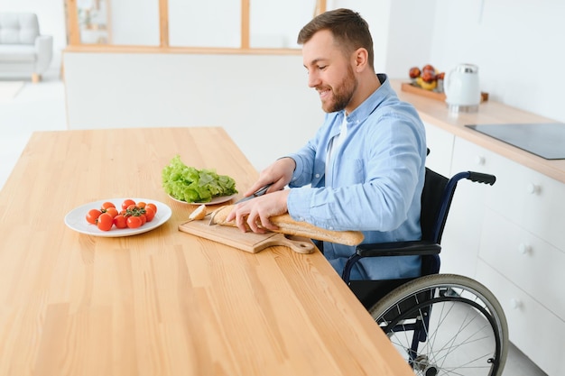 Réfléchi jeune homme handicapé en fauteuil roulant à la maison