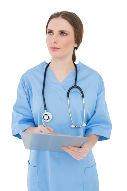 Réfléchie femme médecin tenant un presse-papiers