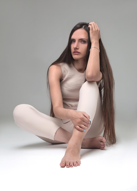 Réfléchie jeune femme assise sur le sol