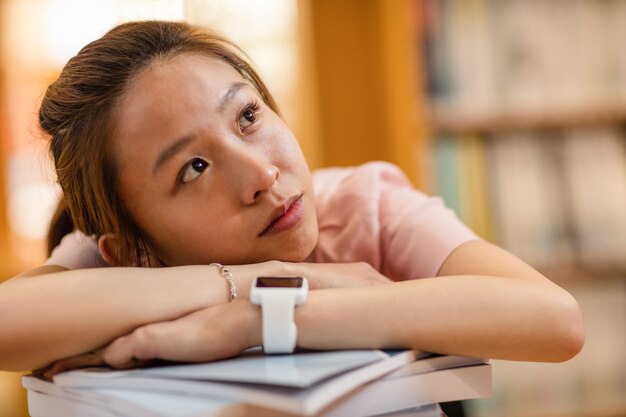 Photo réfléchie jeune femme s'appuyant sur le livre