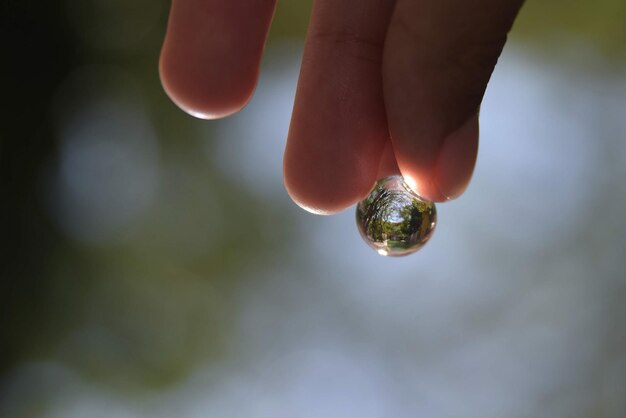 reflet dans une goutte tenue à la main