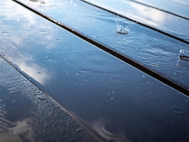 Reflet du ciel dans une flaque d'eau sur des planches en bois