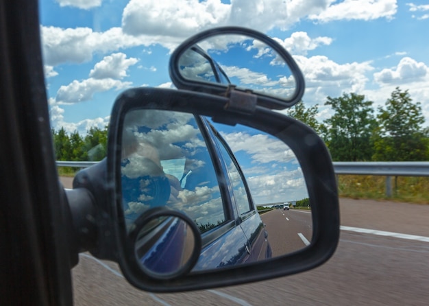 Reflet Du Ciel Avec Des Nuages Dans Le Miroir Latéral D'une Voiture.