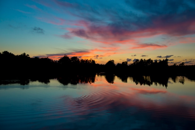 Photo reflet du coucher du soleil sur un étang