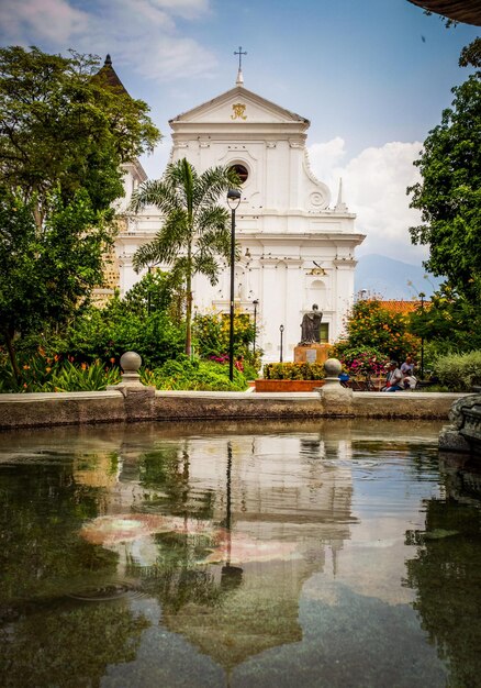 Reflet d'une église au milieu de la place d'une ville coloniale