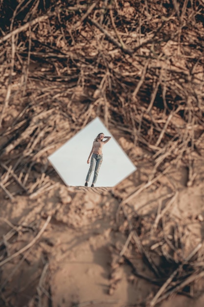 Photo le reflet d'une femme dans le miroir debout contre un ciel clair